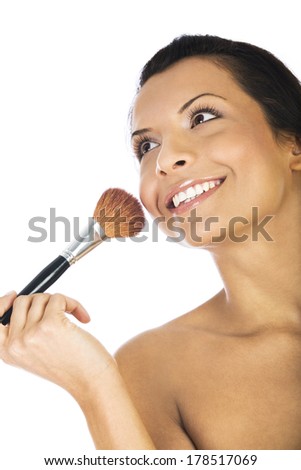 Beautiful young woman applying foundation powder or blush with makeup brush, isolated on white background