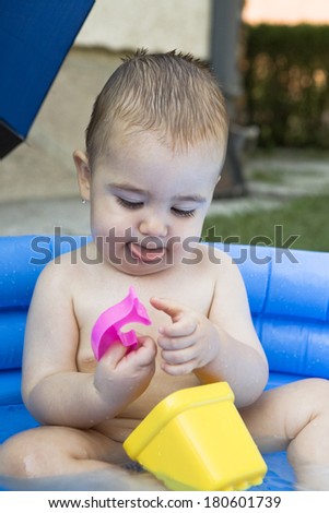 Baby boy playing in kiddie pool
