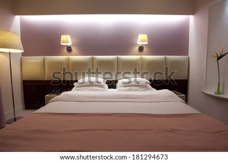 King bed in hotel room in the evening