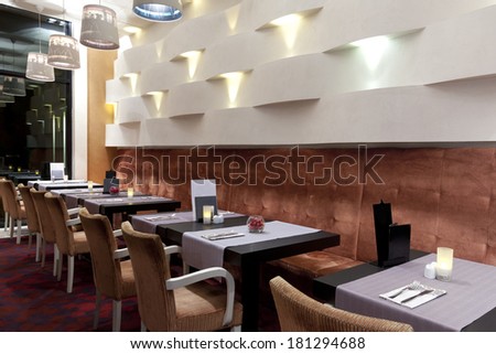 Interior of a hotel restaurant ready for dinner service.