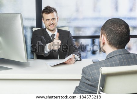 Job well done - concept , boss showing thumb up to one of his employee in the office