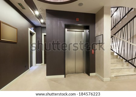 Interior of a corridor with passenger lift and marble stairs