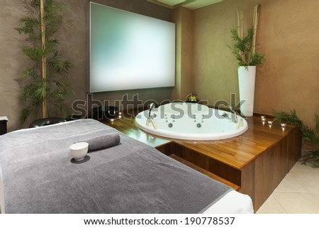 Jacuzzi bath and massage table in hotel spa center