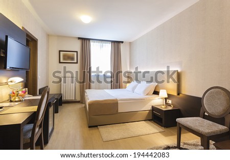 Interior of a hotel bedroom with framed wall mounted tv