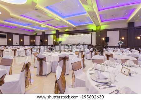 Wedding hall or other function facility with colorful ceiling lights set for fine dining