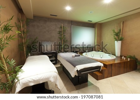 Interior of a room for relaxation treatment with jacuzzi bath and massage table