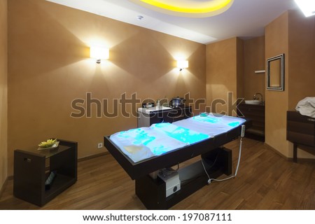 Interior of a room for stone massage with special therapeutic lights in massage bed