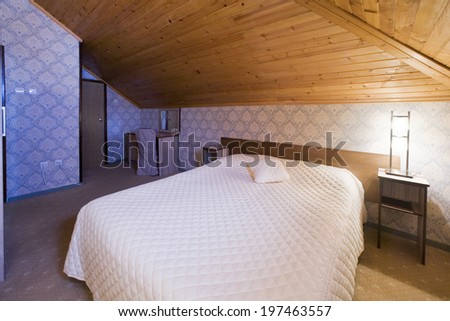 Bedroom in mountain house with wooden ceiling