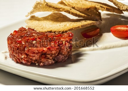 Close up of beef tartar with small toasts.