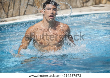 Man jumping in pool splashing water