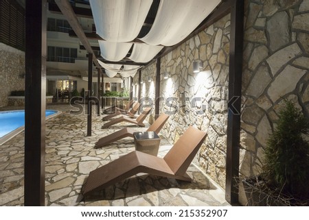 Lounge chairs by the swimming pool at night