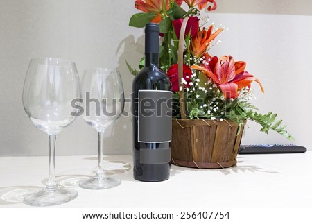 Flowers and bottle of wine in hotel room to welcome new guests