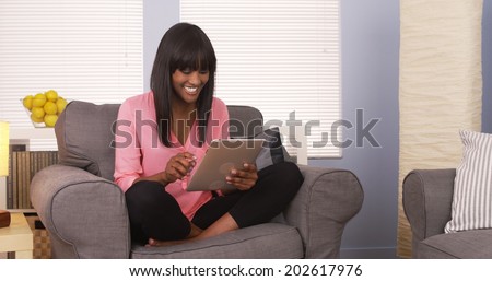 Black woman using tablet in pink shirt