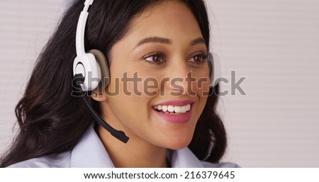 Happy Mexican businesswoman talking with headset