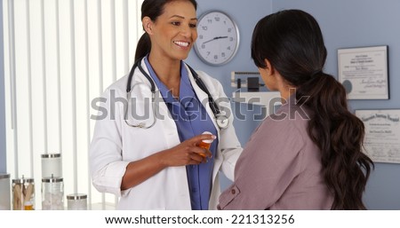Black doctor explaining prescription medicine to female patient