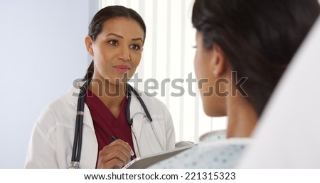 Over the shoulder shot of African American doctor talking to female patient