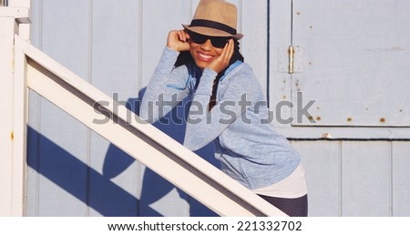 Happy black woman leaning on rail smiling