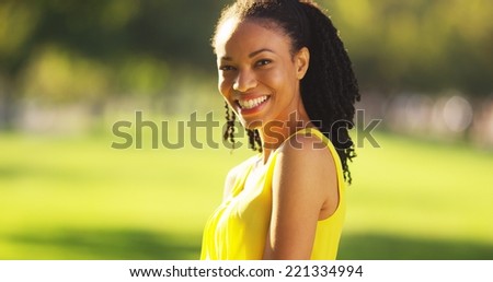 Black woman smiling in a field