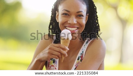 Black woman smiling and eating ice cream