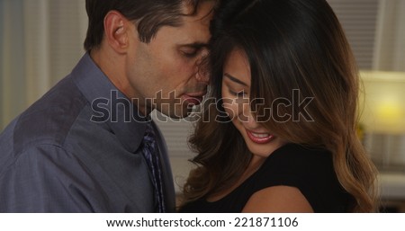 Closeup of boyfriend whispering into girlfriend\'s ear
