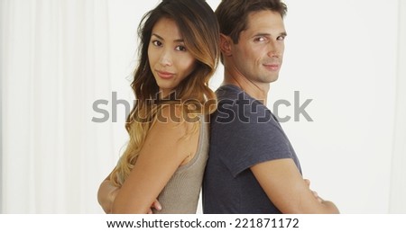 Interracial couple standing back to back