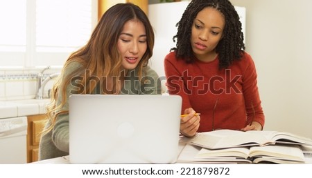 African American and Asian friends studying with laptop computer