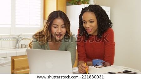African American and Asian college students using laptop computer to study