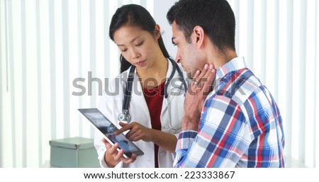 Hispanic patient listening to doctor talk about x-ray