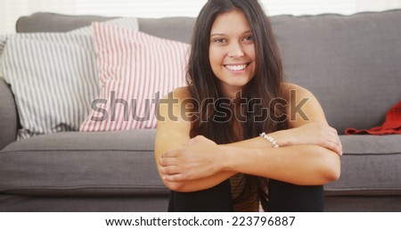 Cute woman sitting in living room laughing and smiling