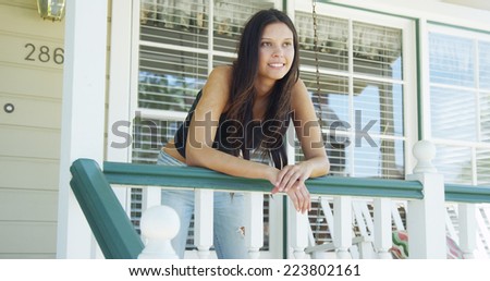 Hispanic woman leaning on rail smiling