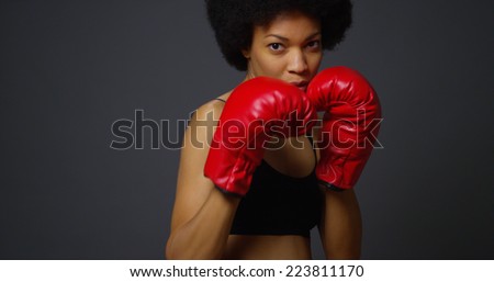 Strong Black Woman Athlete with boxing gloves on dark background