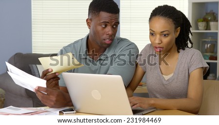 Serious young African American couple making bill payments online