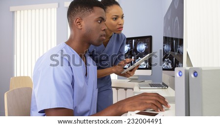 Two Black medical specialists working together at hospital computer