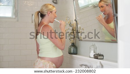 Pregnant woman brushing her teeth