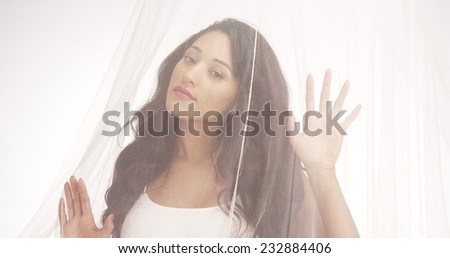 Mexican woman standing behind curtain