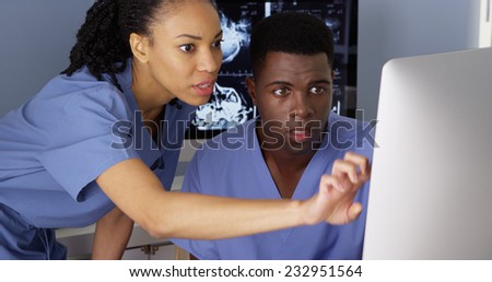 Female medical specialist working with colleague on computer