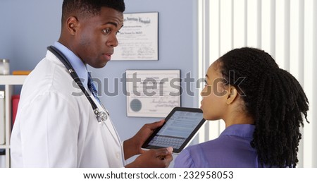 African American doctor taking patient history with tablet computer