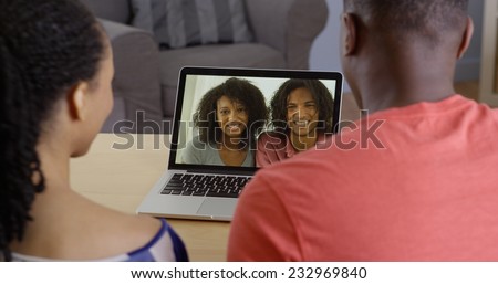 African American couple talking to family over video chat on laptop