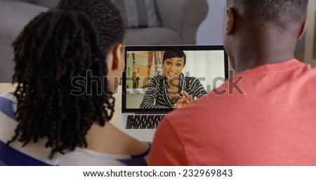 Young African American couple talking to sister over web chat