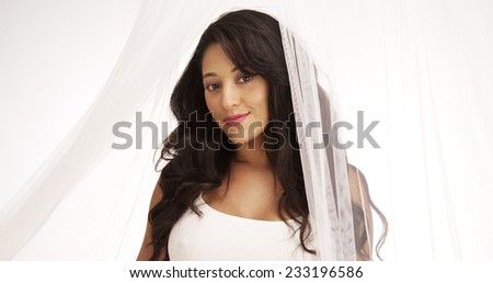 Beautiful Mexican woman standing behind curtain