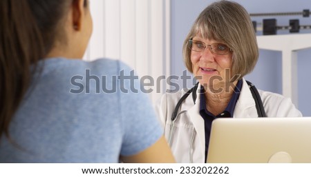 Mature doctor consulting Hispanic woman patient
