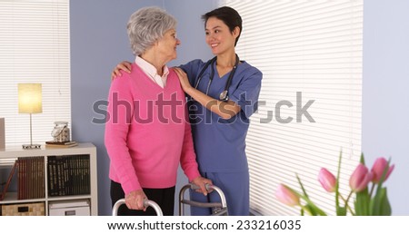 Chinese nurse talking with elderly patient by window