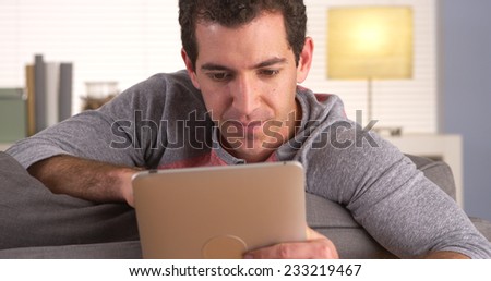 Man sitting on sofa and using tablet