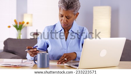 Mature African woman paying her bills