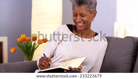 Mature black woman writing in journal