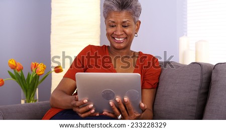 Senior African woman webcamming on tablet