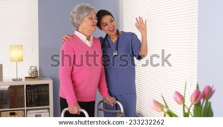 Happy elderly woman patient talking with Asian nurse