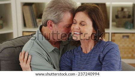 Loving senior couple cuddling on couch