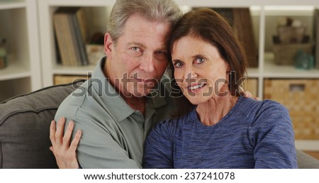 Sweet senior couple cuddling on couch