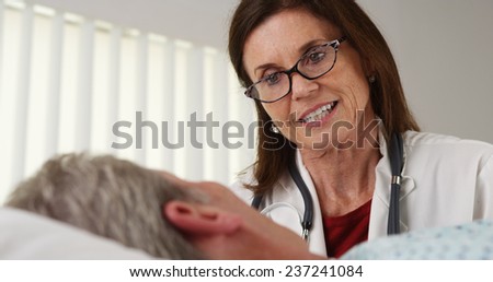 Doctor talking to elderly patient hospital bed